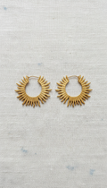 Gold hoop earrings with sunbeam texture